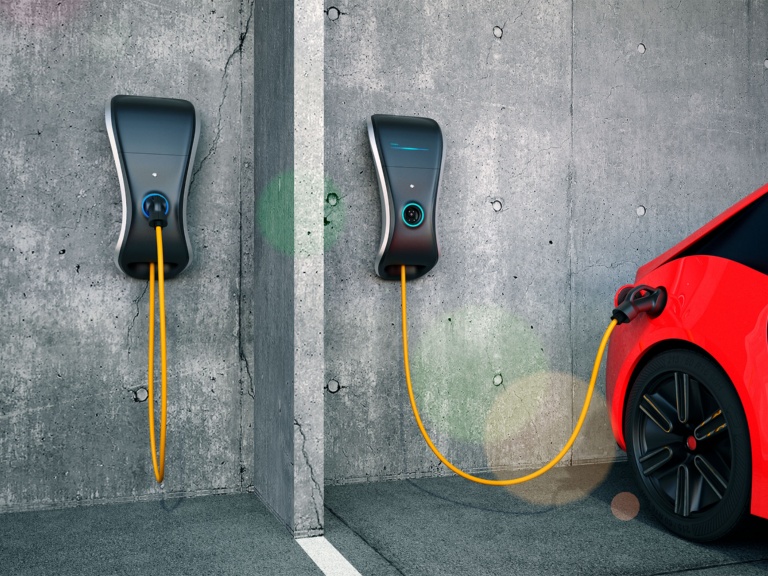 Stecken sie das elektroauto-ladegerät per hand in das elektroauto, um die  batterie aufzuladen, und überprüfen sie gleichzeitig die  batteriestatusanzeige auf dem smartphone. zukünftige nachhaltige und  saubere energie für elektroautos
