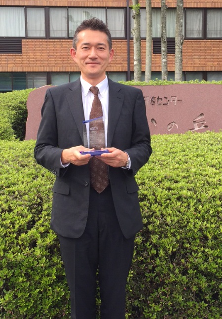 Natsuki Tokubuchi, Head of the Automotive business at Infineon Technologies Japan, holding Toyota Hirose Plant Quality Award