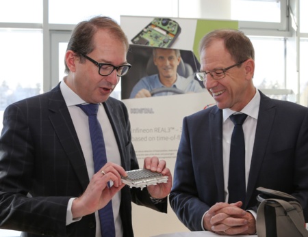 Infineon’s CEO Dr. Reinhard Ploss (right) demonstrates Alexander Dobrindt, German Federal Minister of Transport and Digital Infrastructure, a power module used for motor control in electric vehicles.
