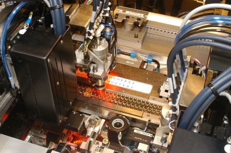 Detail shot inside the FCOS module line: Two high-precision flip-chip and pick-and-place tools operate simultaneously to attach the chip to the tape, thus creating a FCOS chip card module in less than a second.
