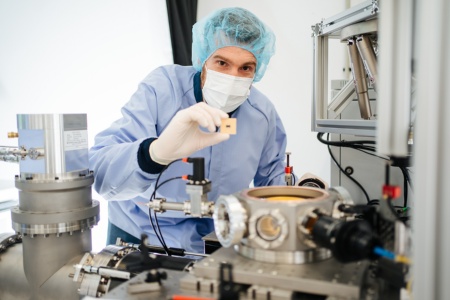 Quantenwissenschaftler mit Infineon Ionenfallenmodul im Quantenlab in Villach. Die Module werden im Cryo-Vakuum getestet.